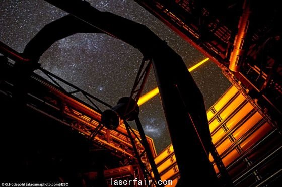 智利歐洲南方天文臺(tái)帕拉納爾天文臺(tái)操作的這個(gè)新PARLA激光器。從圖上可以看到，7瓦特激光器發(fā)出的橙黃色光束從甚大望遠(yuǎn)鏡的望遠(yuǎn)鏡4的穹隆結(jié)構(gòu)射向高空。在背景圖上還能看到大麥哲倫云